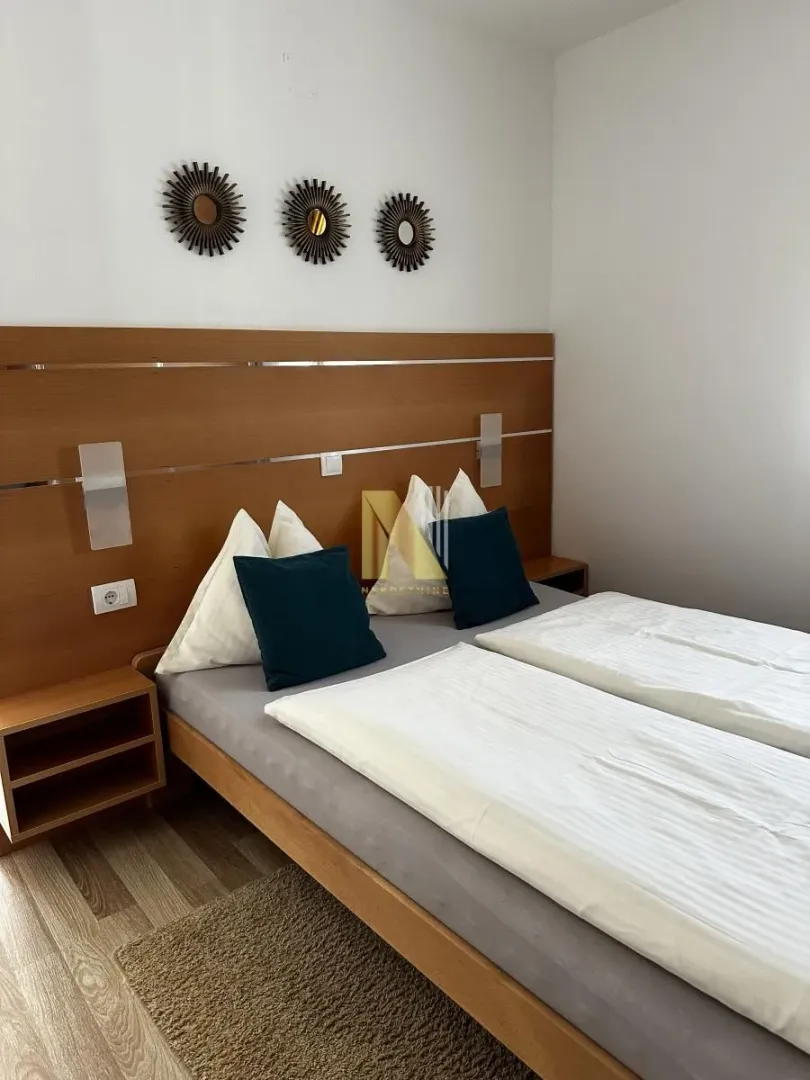 Furnished bedroom with a double bed and wooden headboard.