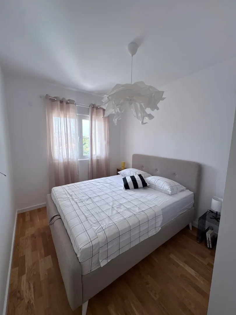 Bright bedroom with a double bed and a window.
