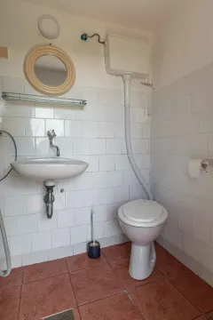 Manje kupatilo sa bijelim pločicama, umivaonikom i wc šoljom. - image 44