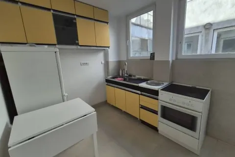 Small kitchen with yellow cabinets, stove, and refrigerator. - image 9