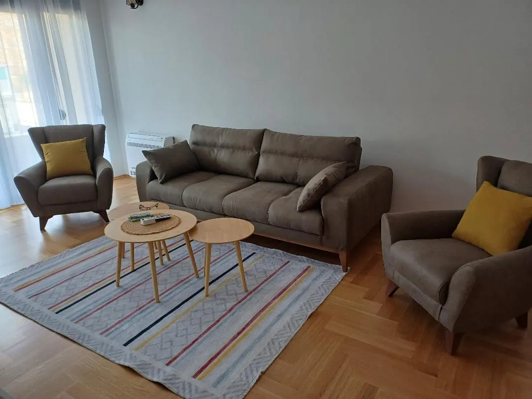 Living room with sofa, armchairs and a wooden coffee table.
