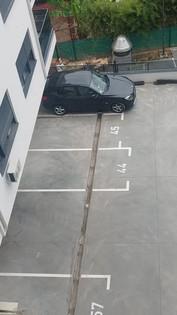Top-down view of parking spaces and part of the building.