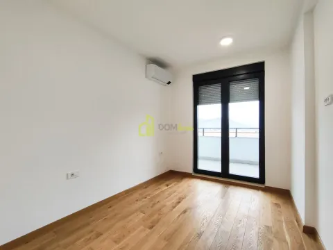 Empty room with wooden flooring, air conditioning unit, and balcony doors. - image 3