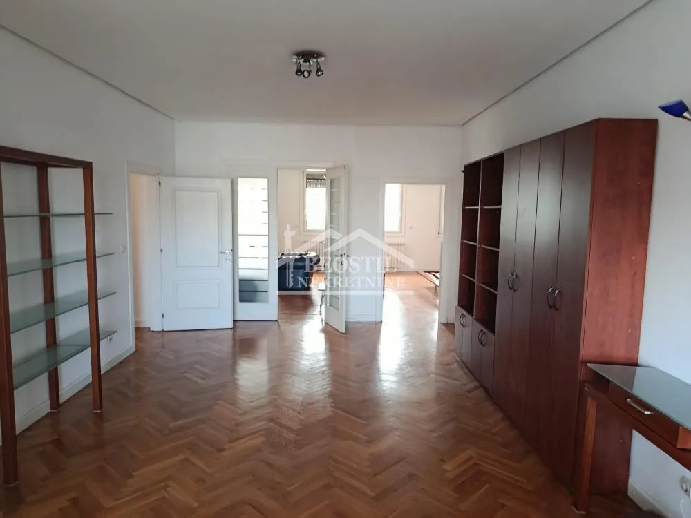 Spacious living room with wooden parquet flooring and built-in wardrobes.