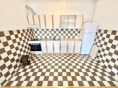 Kitchen equipped with cabinetry, refrigerator, and stove, featuring checkerboard patterned tiles. - image 3