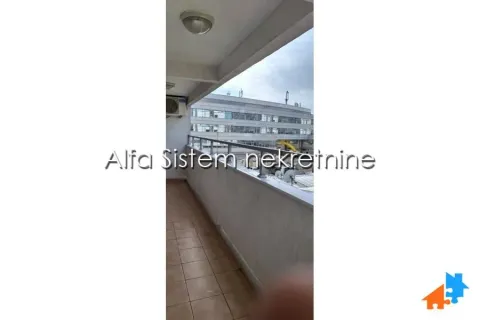 Dugačka popločana terasa sa metalnom ogradom i pogledom na okolne zgrade. - image 21