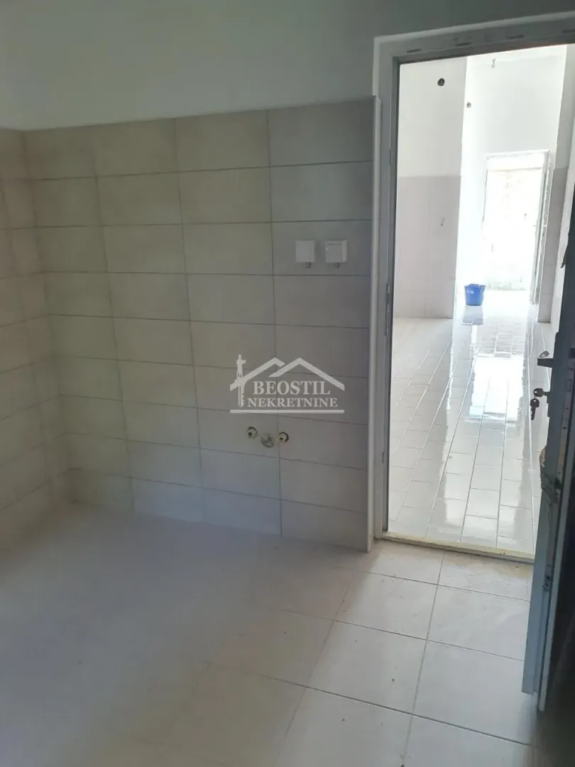 Unfurnished room under construction with ceramic tiles and a door installed.