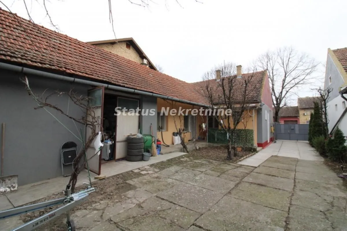 Pogled na dvorište i spoljašnjost kuće sa popločanim delom.
