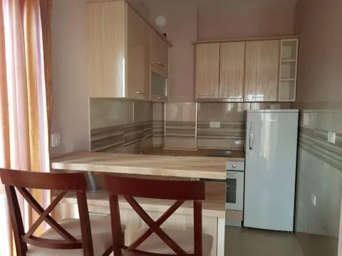 Small kitchen with wooden units, a breakfast bar and a refrigerator. - image 7