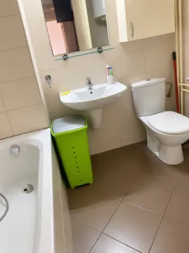 Small bathroom with a washbasin, toilet, bathtub and a mirror. - image 5
