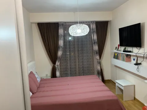 Spavaća soba sa bračnim krevetom, TV-om na zidu i prozorom sa zavjesama. - image 7
