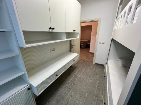 Children's bedroom with a bunk bed and white built-in storage units. - image 8