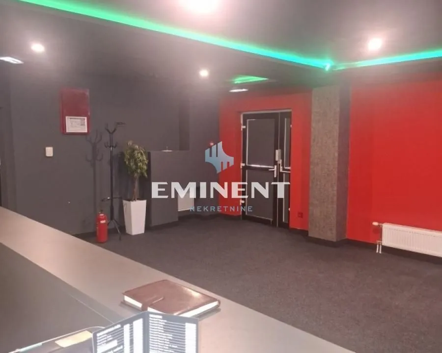 Interior space with red walls and a suspended ceiling with lighting.