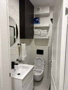 Moderno kupatilo sa bijelim umivaonikom, ogledalom i toaletom. - image 11
