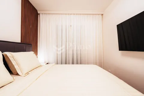 Modern bedroom with a double bed, white curtains and a wall-mounted TV. - image 6