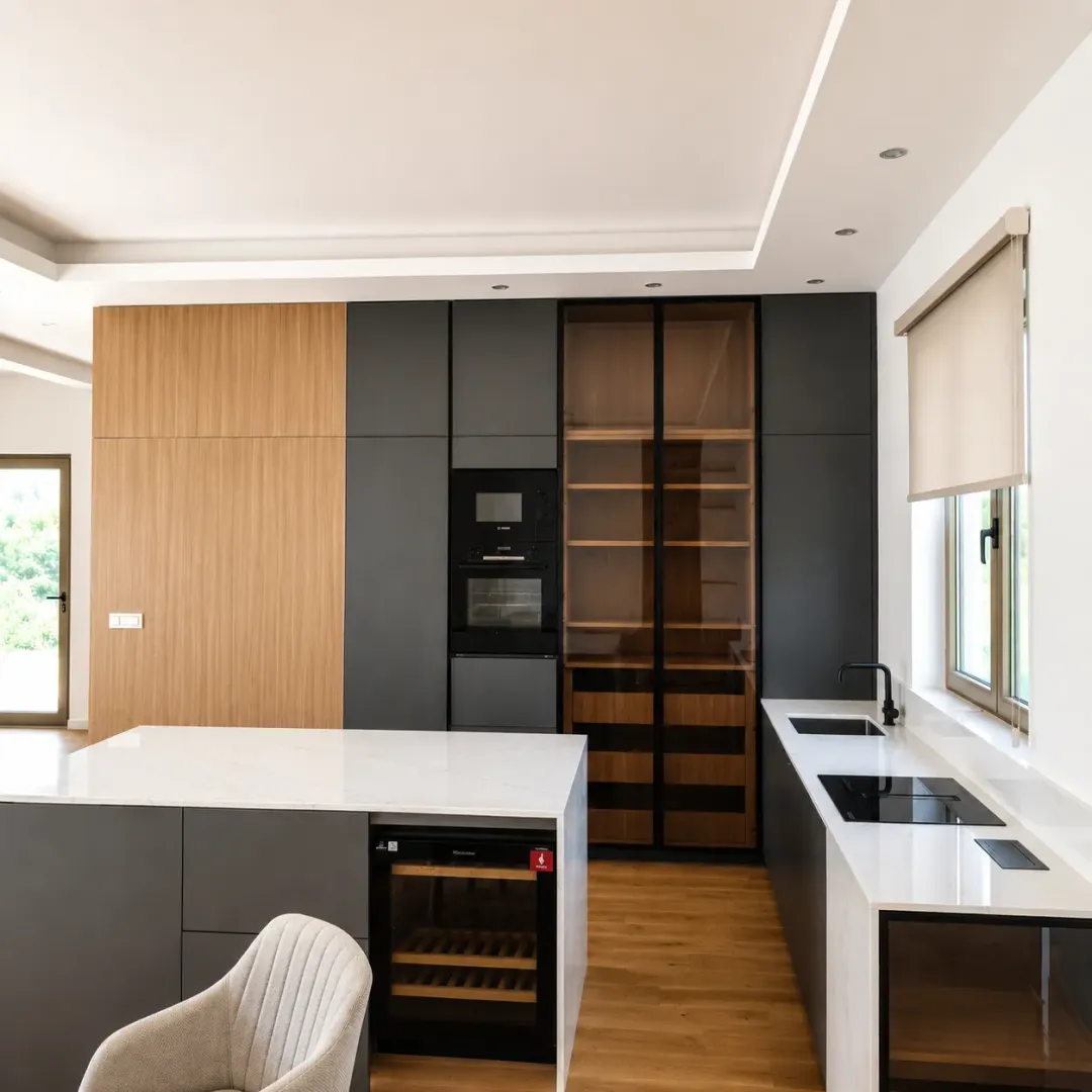 Modern kitchen with an island, built-in appliances, and dark cabinetry combined with wood.