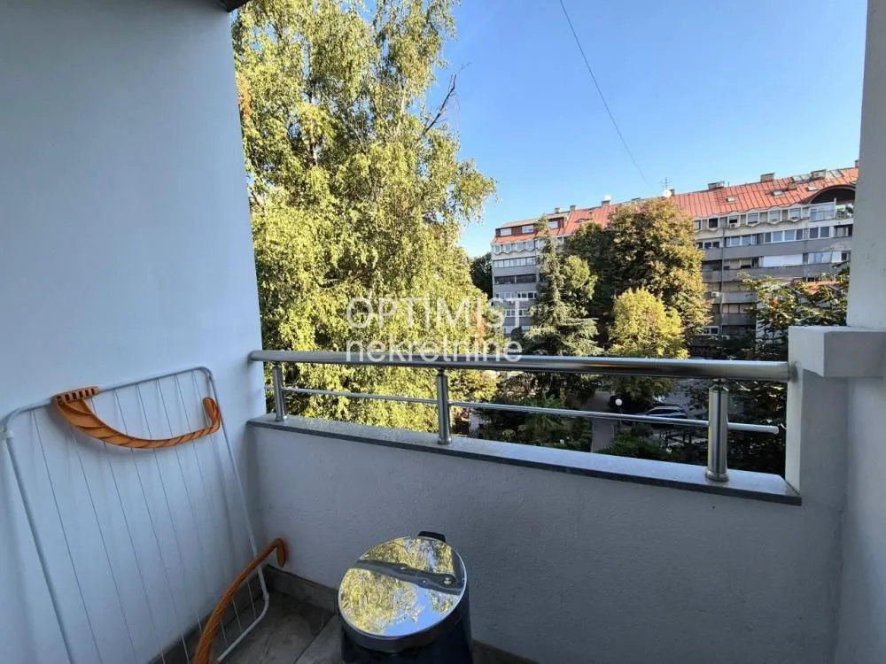 View from the balcony overlooking surrounding greenery and buildings.