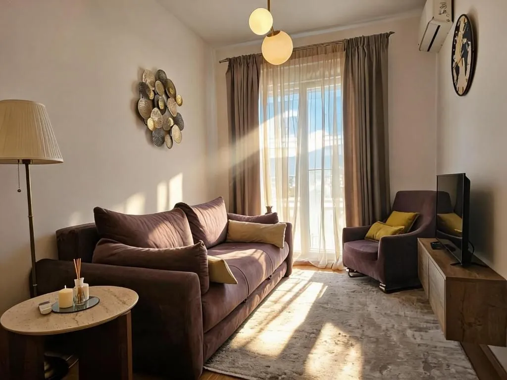 Cozy living room with a sofa, TV, and sunlight streaming through the window.