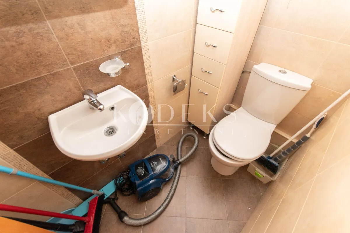 Smaller bathroom with a washbasin, toilet bowl and chest of drawers.