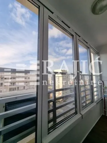 Enclosed balcony with a city view.
