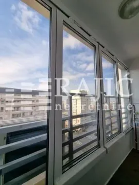 Enclosed balcony with a city view. - image 10