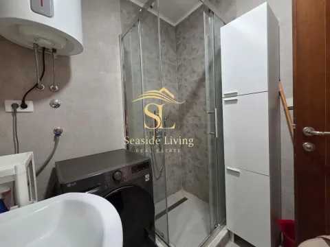 Bathroom with a shower cabin, washbasin, and washing machine. - image 12