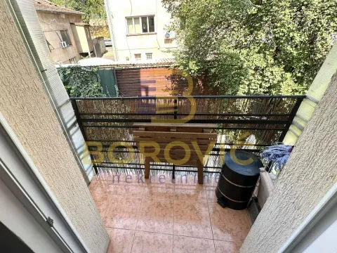 Manji popločani balkon sa ogradom i pogledom na dvorište i okolne zgrade. - image 10