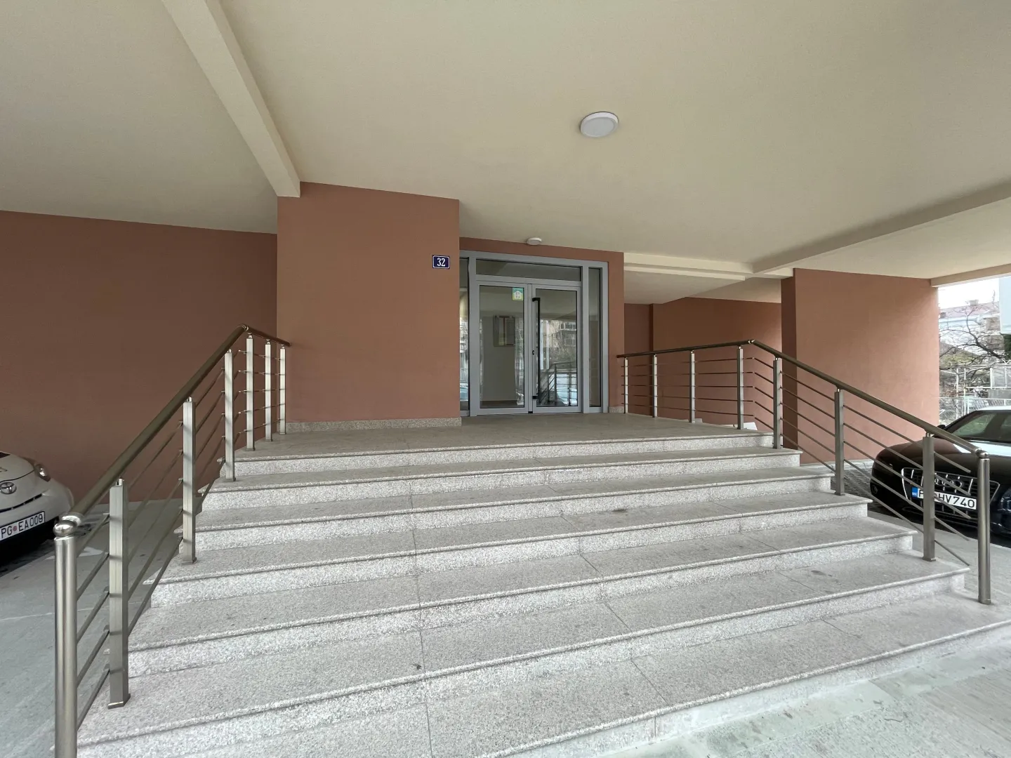 Glavni ulaz u stambenu zgradu sa stepeništem i rukohvatima.