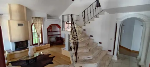 Spacious living room with a fireplace and indoor staircase. - image 10