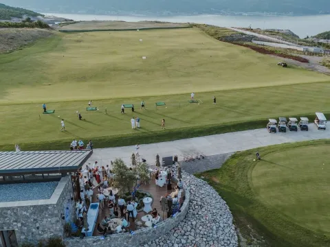 Pogled iz vazduha na spoljašnjost objekta i golf teren sa ljudima. - image 5