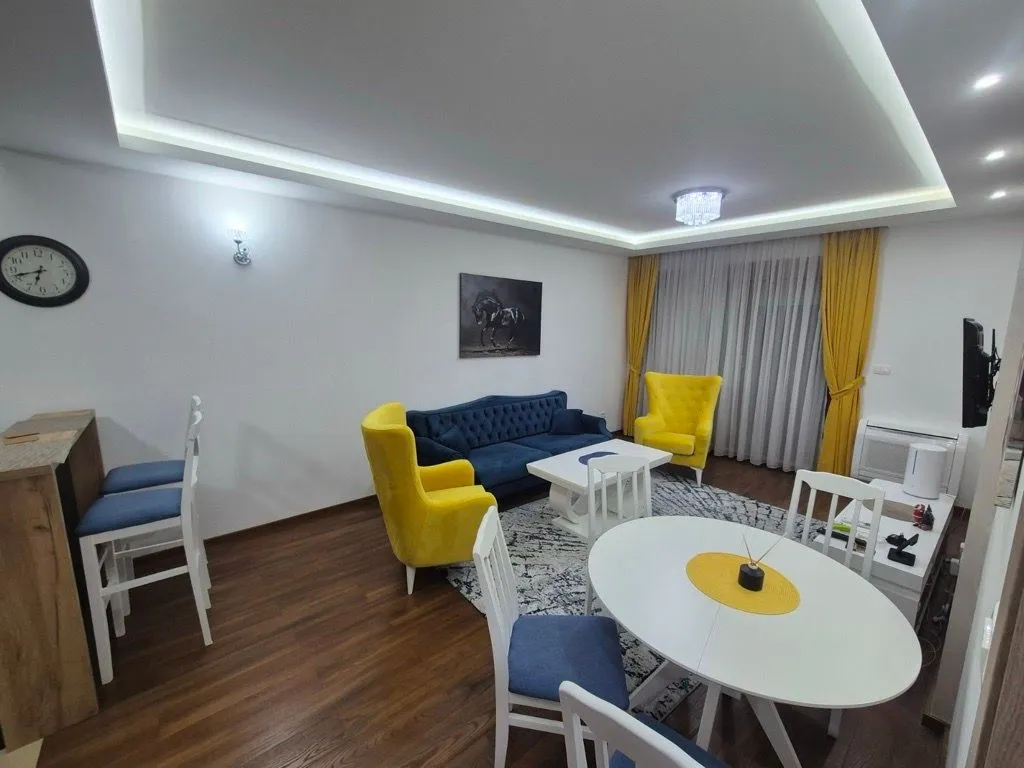 Spacious living room with a sofa set, dining table, and a bar counter.