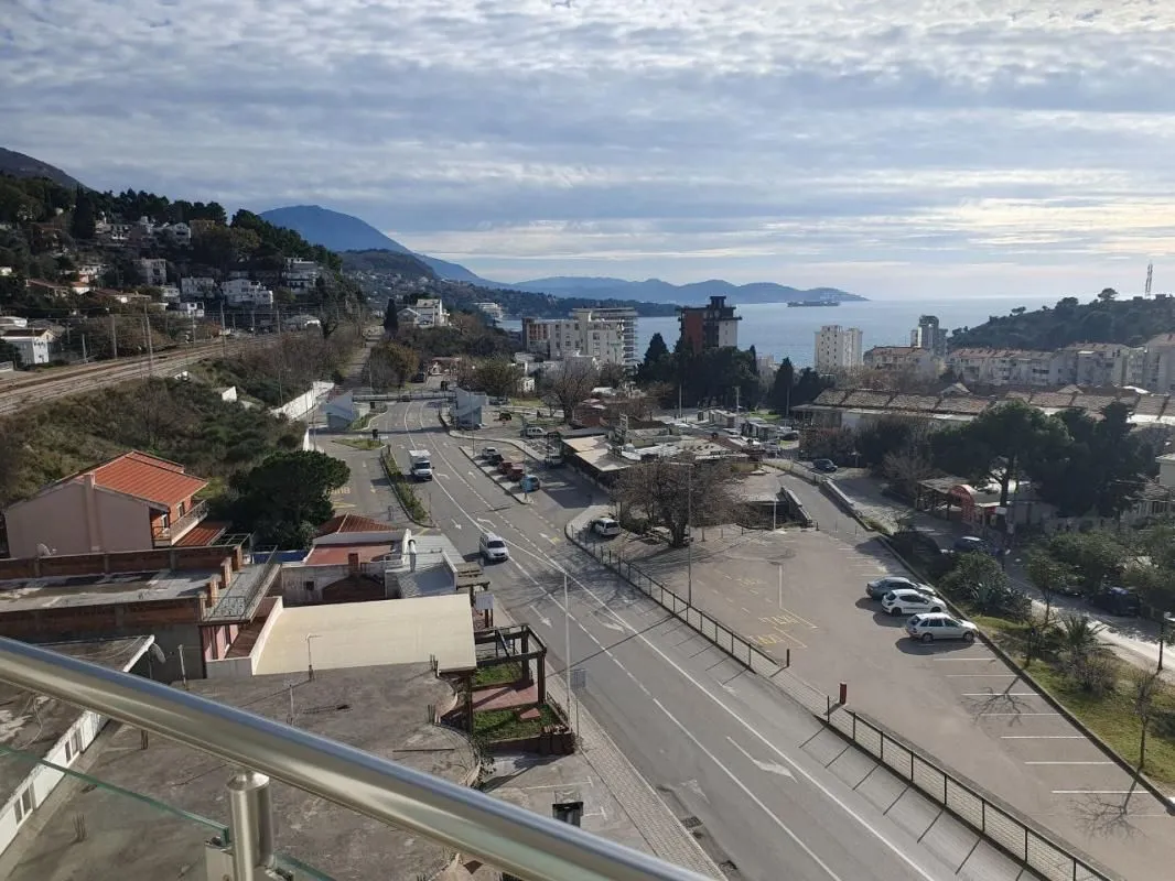 View from the terrace overlooking the city, street, and sea.
