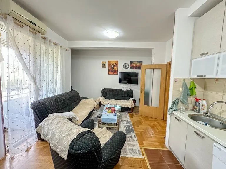 Dnevni boravak sa garniturom i trpezarijskim dijelom povezan sa kuhinjom.