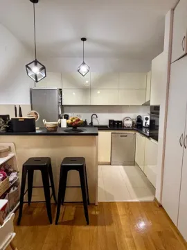 Modern kitchen with a bar counter and bar stools. - image 9