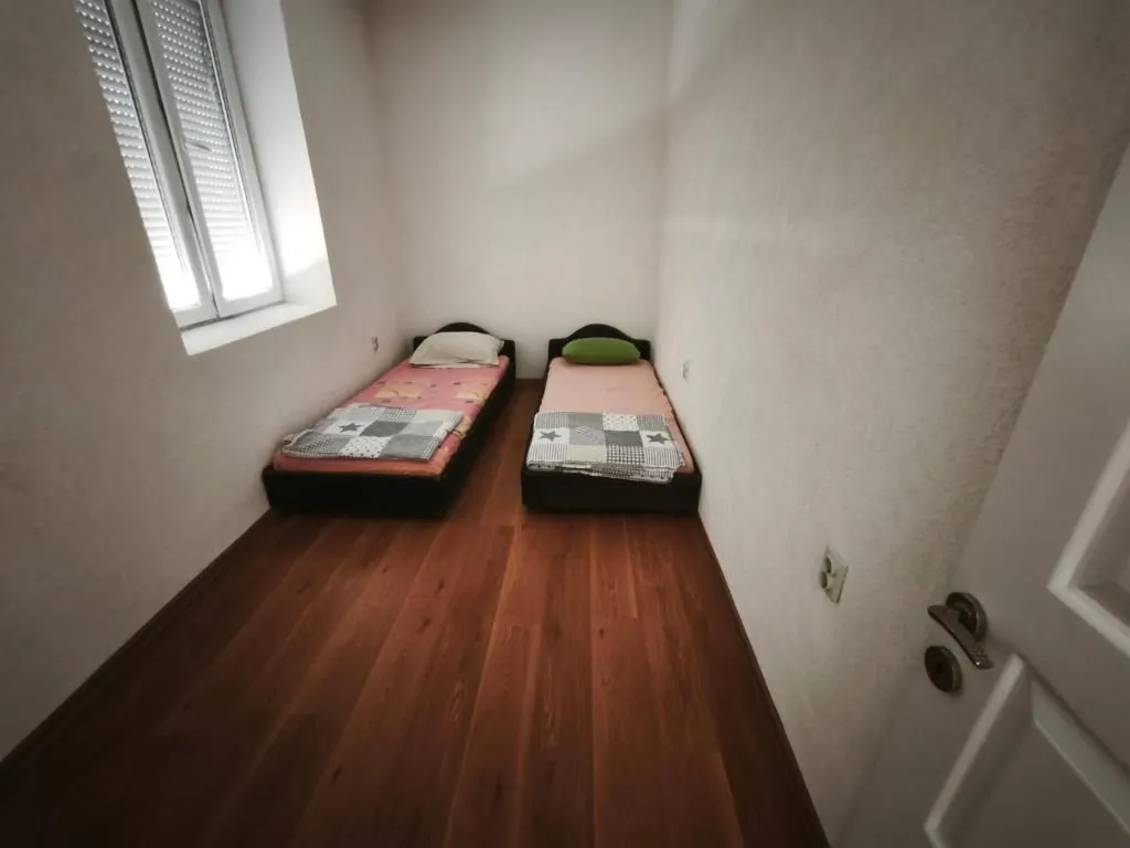 Small bedroom with two single beds and a window.