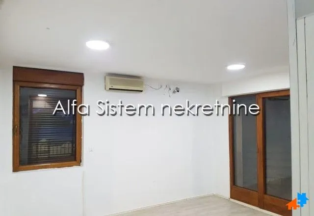 Empty room with white walls, wooden joinery, and an air conditioning unit.