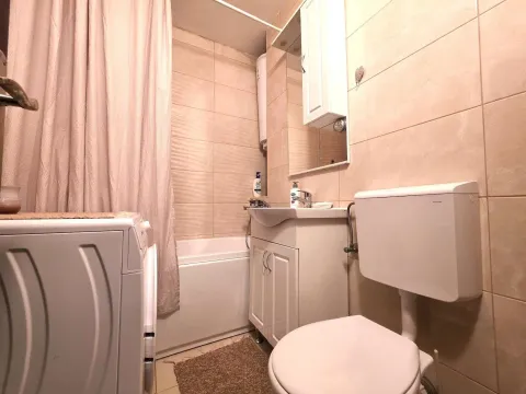 A compact bathroom equipped with sanitary fixtures, a bathtub, and a washing machine. - image 15