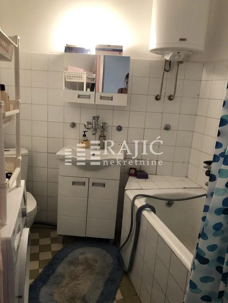 Smaller bathroom with a bathtub, washbasin, and toilet.