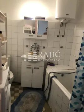 Smaller bathroom with a bathtub, washbasin, and toilet. - image 6
