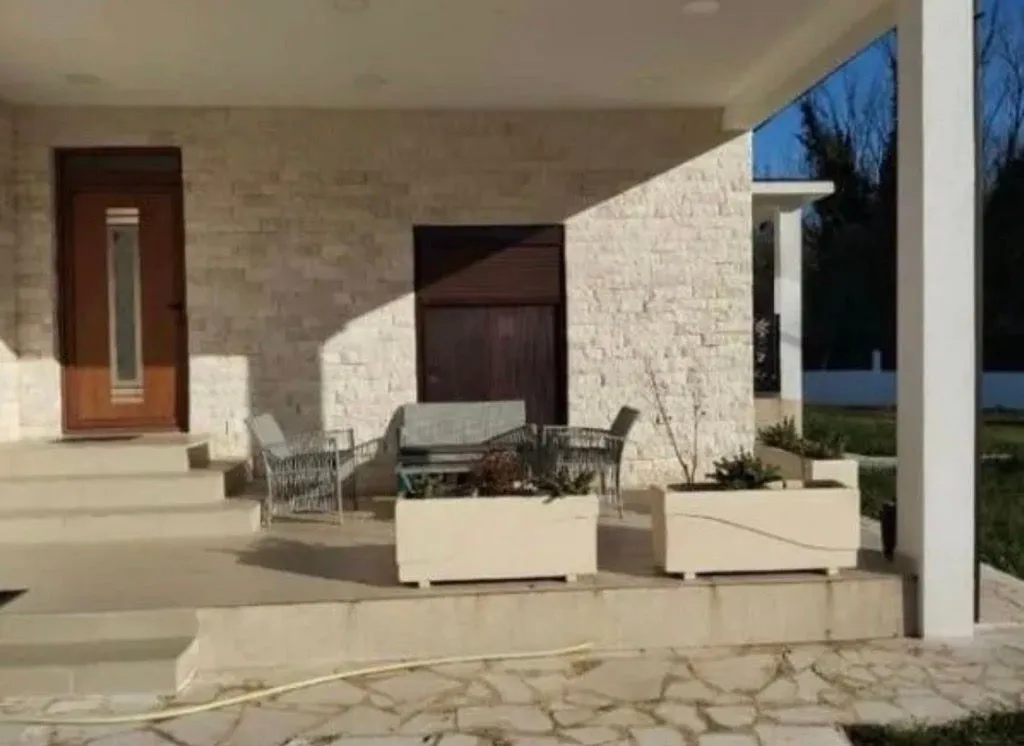 Covered terrace in front of the house with seating furniture.