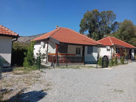 View of the yard and exterior of single-story houses with red roofs. - image 2