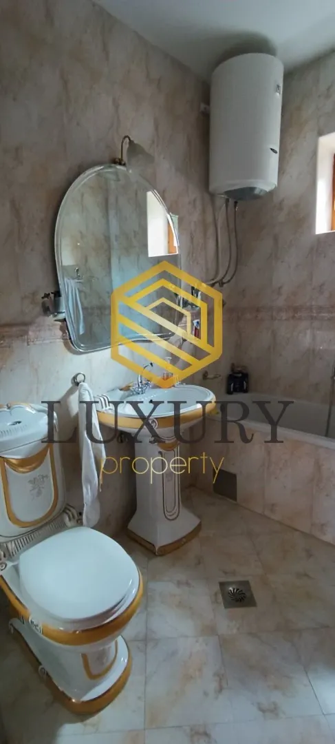 Small bathroom with a sink, toilet, and water heater.