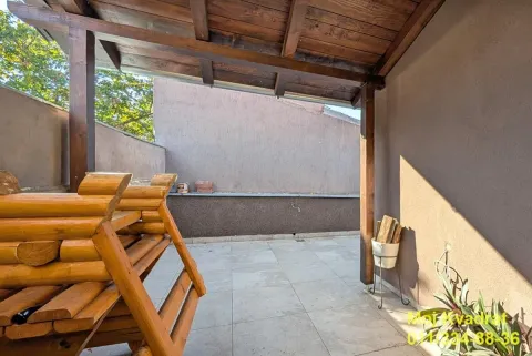 Covered terrace with wooden structure and stacked wooden benches. - image 4