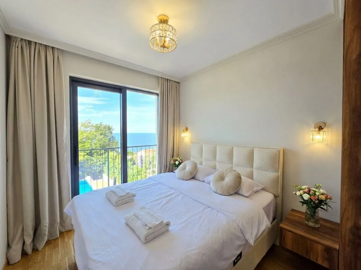 Spavaća soba sa bračnim krevetom i pogledom na more.