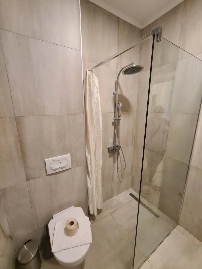 Moderne kupatilo sa tuš kabinom i ugradnim wc šoljom.