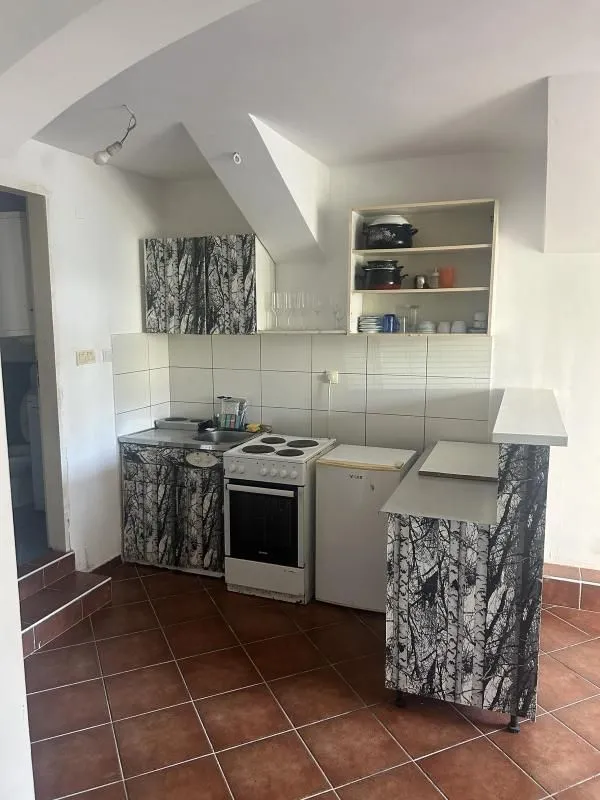 Small kitchen with a stove, refrigerator, and wood-patterned cabinets.
