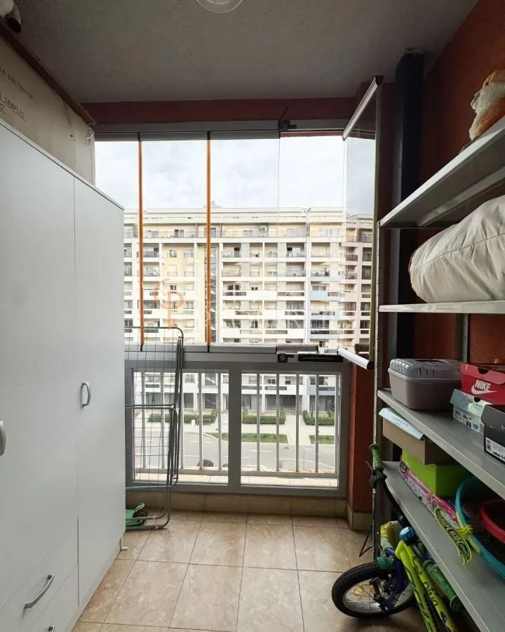 Zastakljeni balkon sa ormarom i policama za odlaganje stvari.