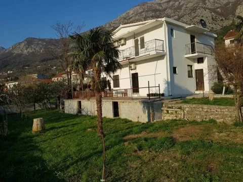 View of the yard and a white two-story house with terraces and a mountain landscape in the background. - image 8