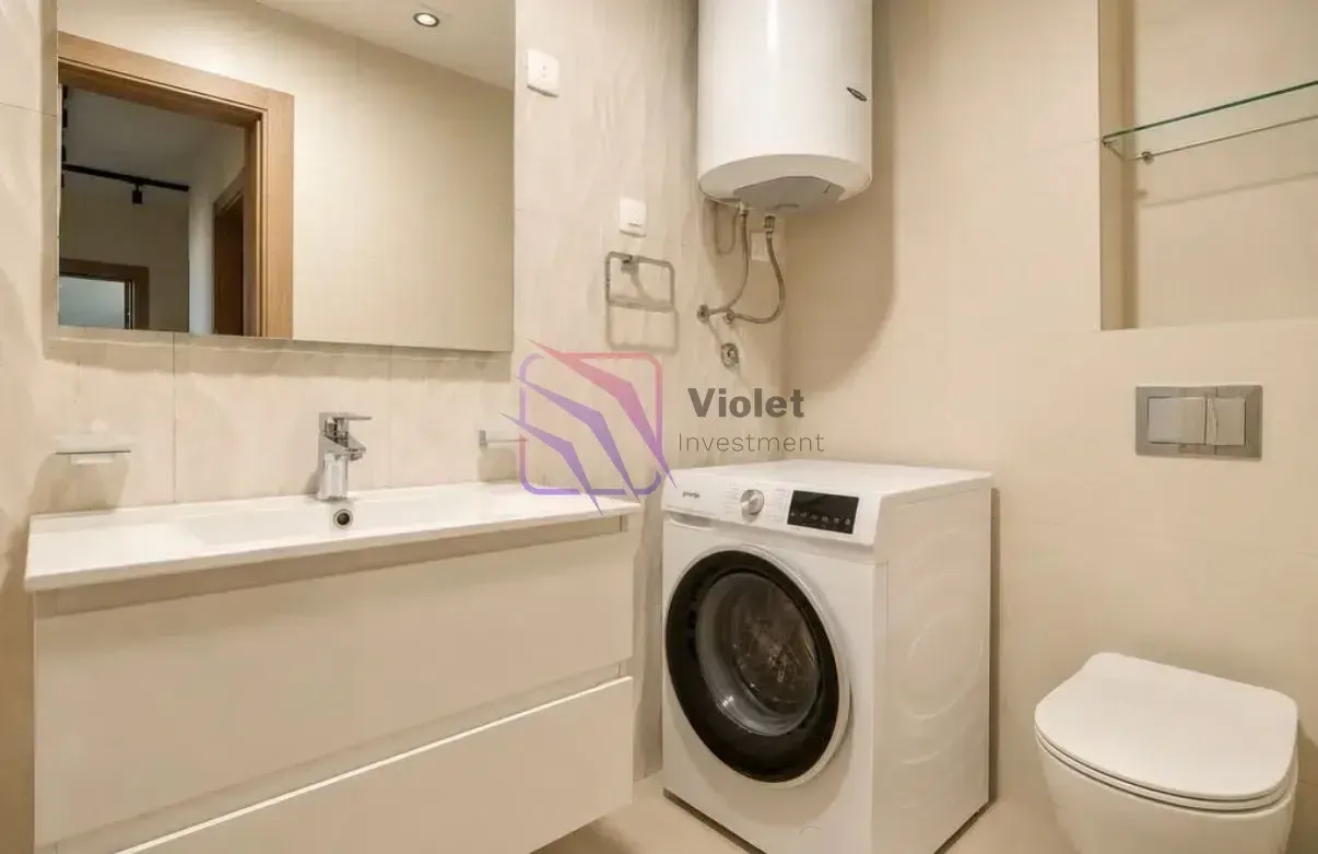 Bathroom equipped with a washbasin, washing machine, water heater, and toilet.