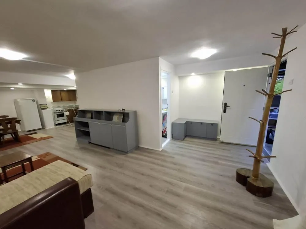Pregled dnevnog boravka sa ulaznim vratima i pogledom na kuhinju.